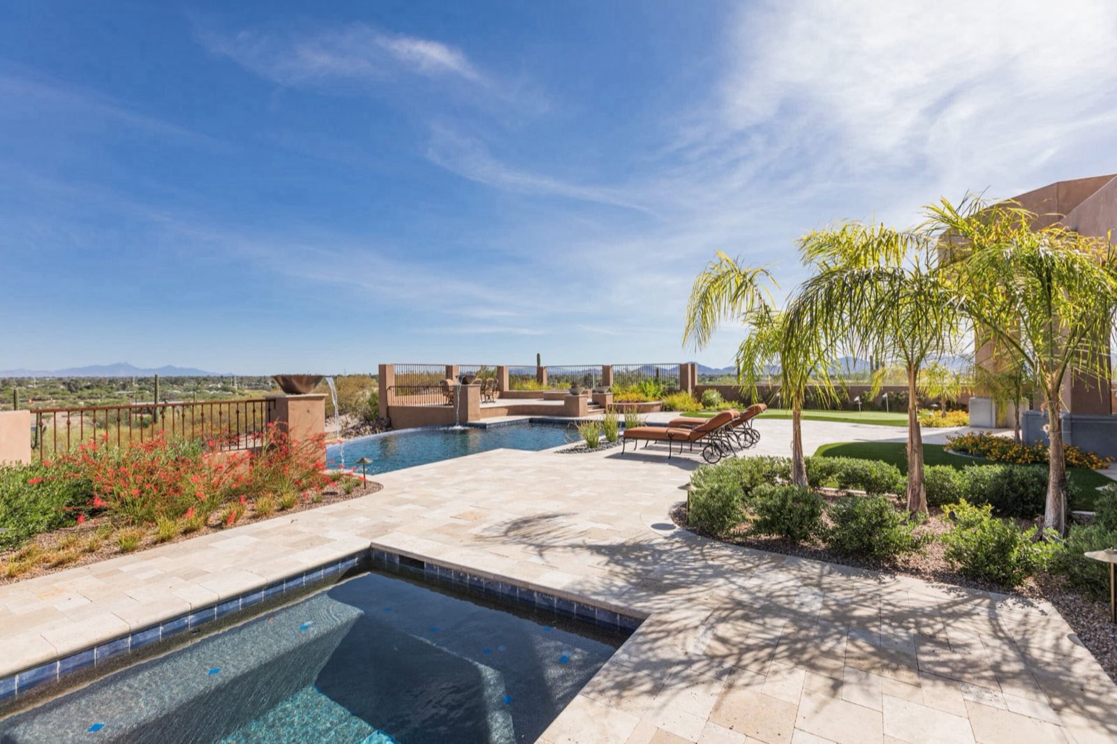 Travertine paver pool patio with putting green and mountain views in Tucson