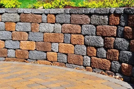 Decorative stacked block retaining wall with a paver base in a Tucson desert yard